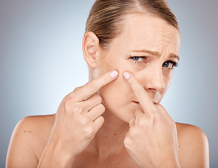 Image showing Face, skincare and woman squeeze acne, pimple or blackhead in studio on a gray background. Wellness, dermatology and cosmetology portrait of sad female model from Canada worried about skin health.