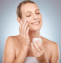 Image showing Skincare, beauty and cream on face, woman on studio background for skin and body care. Happy, clean and fresh bathroom beauty routine for model. Sun protection application of anti aging sunscreen.