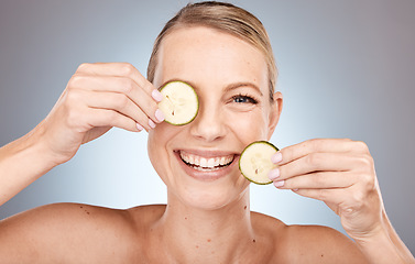 Image showing Woman, face and cucumber for skincare grooming in organic healthcare, vegan collagen wellness and facial product treatment. Portrait, smile and happy beauty model with vegetables in Canada self care