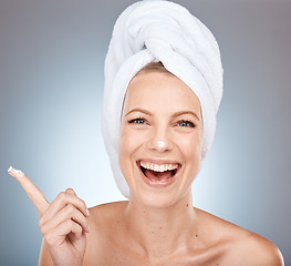 Image showing Beauty, skincare and product with portrait of woman and facial cream for shower, luxury and spa. Sunscreen, cosmetics and lotion on face of model with towel for cleaning, moisturizer and dermatology