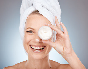 Image showing Woman, face or skincare cream in grooming routine, healthcare wellness or collagen treatment on gray studio background. Portrait, happy smile or beauty model or eye care product in Canada dermatology