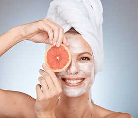 Image showing Woman, skincare and mask with grapefruit, smile or happy in studio for wellness, self care or beauty. Model, skin and cream for soft glow with facial, fruit and happiness by grey studio background