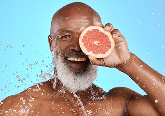 Image showing Portrait, skincare or black man with grapefruit studio with water splash on blue background with mockup space. Smile, face or senior male model on healthy diet for beauty, detox or vitamin c benefits