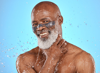 Image showing Portrait, facial and senior man in studio for wellness, cleaning and skin mask with water splash on blue background. Face, elderly man and skincare mask, beauty splash and luxury product in shower