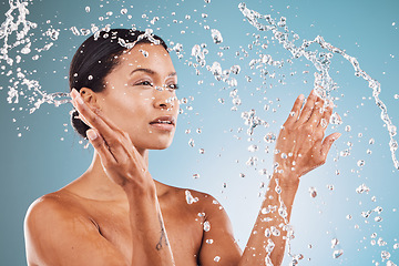 Image showing Beauty, skincare and black woman with splash of water for cleaning, hygiene and body care routine. Self care, wellness and healthy skin of model thinking with water splash in blue studio.