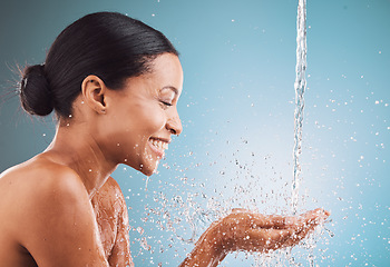 Image showing Skincare, health and black woman with water splash, wellness and hygiene against a blue studio background. Cosmetics, young female and girl with smile, drops and natural beauty for washing and relax.