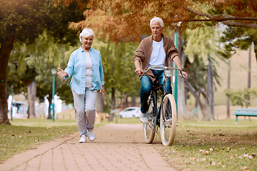 Image showing Senior couple, walking and bike at park, talking and bonding together mock up. Love, retirement and elderly man cycling on bicycle with happy woman speaking outdoors for exercise, health and wellness