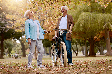 Image showing Nature, laugh and senior couple with bicycle to travel in autumn park for funny romantic date, outdoor peace or freedom. Love, retirement marriage bond and laughing man and woman with cycling bike