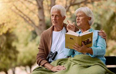 Image showing Birdwatching, book and binoculars with a senior couple sitting on a park bench together in nature. Forest, love and retirement with a mature man and woman in a garden to relax with a summer view