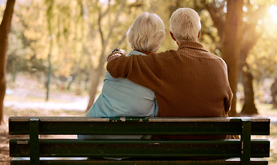 Image showing Love, hug and old couple in a park on a bench for a calm, peaceful or romantic summer marriage anniversary date. Nature, romance or back view of old woman and elderly partner in a relaxing embrace