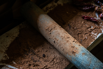 Image showing Grinding cacao beans with chili peppers