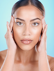 Image showing Portrait, face and beauty with a model black woman touching her skin in studio on a blue background. Skincare, cosmetics and antiaging with an attractive young female posing for natural treatment