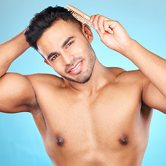 Image showing Beauty, hair and brush with portrait of man for grooming, hygiene or self care routine. Salon, hairstyle and treatment with model for cosmetics, brushing and product against blue background in studio