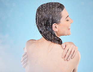 Image showing Shower, happy and beauty of wellness woman with body cleaning, self care and grooming routine. Health, hydration and water drops on back of skincare model washing in blue studio with smile.