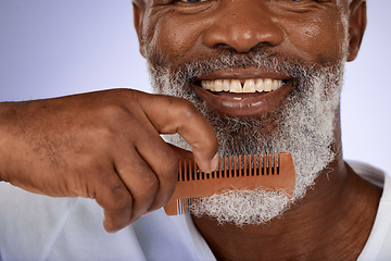 Image showing Senior man, face and beard comb in studio isolated on a purple background. Hair care, smile and wellness of happy elderly black man with grooming product for facial hair wellness, health and hygiene.