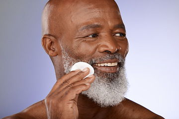 Image showing Face, skincare and antiaging with a senior black man exfoliating his skin in studio on a gray background. Beauty, cleaning and cleansing with a mature male using a cotton pad for natural treatment