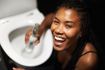 Image showing Black woman, face and drinking alcohol by toilet in party event, birthday celebration or nightclub social gathering. Portrait, smile or happy drunk person with beer bottle in music festival bathroom