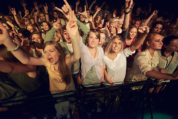Image showing Concert, music festival and crowd with rock hands sign for singing, dance and night event, performance and celebration in dark. Group of people, audience and gen z lifestyle techno, rave and party