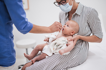 Image showing Pediatrician administring oral vaccination against rotavirus infection to little baby in presence of his mother. Children health care and disease prevention