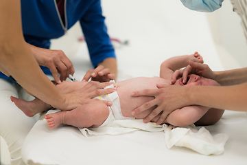 Image showing Baby beeing vaccinated by pediatrician in presence of his mother. Preventive vaccination against Diphtheria, whooping cough, tetanus, hepatitis, haemophilus influenzae, pneumococcus, poliomyelitis