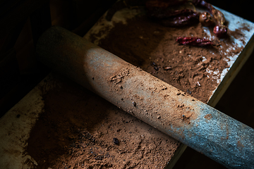 Image showing Grinding cacao beans with chili peppers