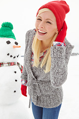 Image showing Christmas, woman and snowman outdoor in winter, happy smile and cold in Austria during festive holiday or season. Young female, happiness and fun outside in nature, smiling and laugh with portrait