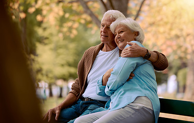 Image showing Couple, elderly and hug in park during retirement, sitting on park bench with love and spending quality time outdoor. Happy, trust and support with marriage, senior man and woman retired in New York.