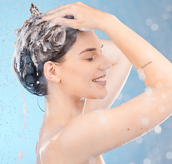 Image showing Woman, shampoo and shower for hair care, clean or hygiene on blue studio background. Young female, girl or lady wet, water or bubbles for natural beauty, morning routine or skincare to relax or smile