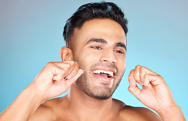 Image showing Floss, Mexican man and dental health for smile, fresh breath and after brushing teeth against blue studio background. Oral health, Latino male and string to clean mouth, hygiene and morning routine.
