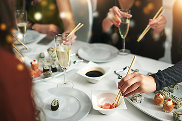 Image showing Sushi, friends and eating food together for nutrition, diet and social get together in a restaurant. Meal, asian seafood and alcohol drink with hungry people eat and champagne while gathering