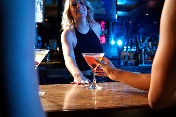 Image showing Bartender, nightclub and cocktail drink with mixologist worker at counter serving alcohol at a restaurant, bar or new years party. Hand of woman on glass for drinking, celebration and service