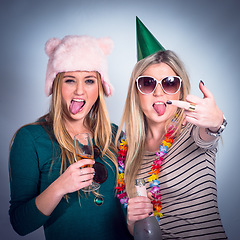 Image showing Party, drunk friends and drinking alcohol for celebration while crazy, rude and happy on studio background. Women with wine glass and bottle showing middle finger to celebrate birthday drink together