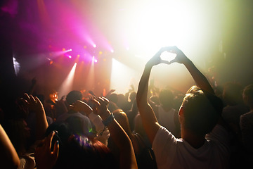 Image showing Crowd at concert, music and watch band performance, music festival, light and energy with audience back view. People dance with hands in heart shape, musician on stage and festival in Florida.