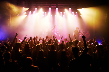 Image showing Festival, music and concert with energy of crowd cheering for live rock band on stage. Event, fans and happy people cheer for energetic performance at music festival in Los Angeles, USA.