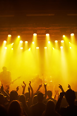 Image showing Concert, party and music with a crowd or audience of people watching a live performance on stage. Event, hands and festival with man and woman friends dancing at a social celebration for fun