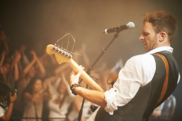 Image showing Man, musician or playing guitar at live band concert, nightclub event or party show for diversity crowd, people or friends. Guitarist, stage artist and microphone for audience dance floor at festival