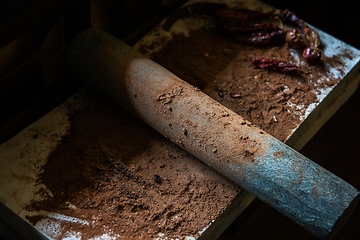 Image showing Grinding cacao beans with chili peppers