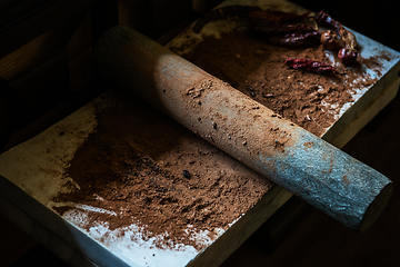 Image showing Grinding cacao beans with chili peppers