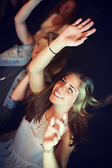 Image showing Women, arms up or dancing in night party, music festival or social gathering event to live music, band performance or techno friends rave. Smile, happy or woman dancer on crowd dance floor and energy