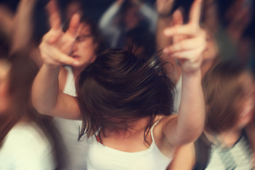 Image showing Dance, motion blur and music festival with a woman moving with rhythm in a crowd at a concert or show. Party, freedom and energy with a young female dancing at a disco or celebration event