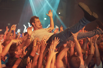 Image showing Music, party and crowd surfing with man at concert for rock, celebration and festival. Energy, light and dance with audience listening to live band show performance at disco, summer break and dj