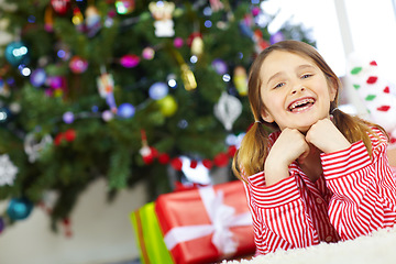 Image showing Young girl, holiday celebration and Christmas morning at family home, ready for gift and happy with braces in portrait. Excited to celebrate, kid and happiness for present, Christmas tree decoration