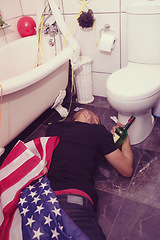 Image showing Party, hangover and drunk man in bathroom sleeping after celebration, festival and house party in usa. After party, alcohol and male on floor by toilet of social event, new years eve and house party