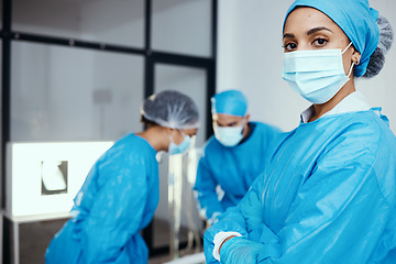 Image showing Medical, surgeon or doctor in scrubs and face mask in hospital with staff working during covid virus crisis for health and wellness with safety. Portrait of a woman with arms crossed for healthcare