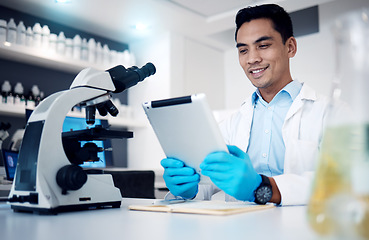 Image showing Science, tablet and microscope with a man at work in a laboratory for research or innovation. Doctor, medicine and healthcare with a male engineer working in a lab for future medical development