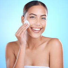 Image showing Skincare portrait, woman with cotton product and cleaning face in studio with blue background aesthetic. Makeup removal for healthy hygiene, luxury cosmetics facial and happy girl with beauty glow