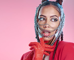 Image showing Punk, goth and stylish woman with face chains posing on a pink studio background with cool attitude. Creative makeup, cosmetics and female with trendy and edgy facial metal accessories