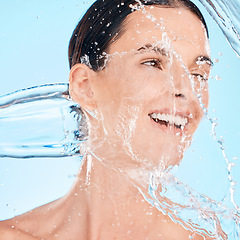 Image showing Water splash, happy or woman in shower cleaning her face or body in self care grooming morning routine. Blue background, skincare or healthy model smiles washing for beauty or wellness in studio