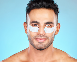 Image showing Beauty, eye patch and face with man and eye care, cosmetic treatment portrait with healthy skin against blue studio background. Dermatology, cosmetics mockup and skin care with grooming and facial.