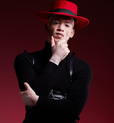 Image showing Man, fashion style or vitiligo skin on red background studio in empowerment, self love or attitude. Portrait, aesthetic or model with cool, stylish or edgy clothes or South Africa facial pigmentation